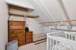 This charming nursery features a cozy, slanted-ceiling design, perfect for creating a warm and inviting space.