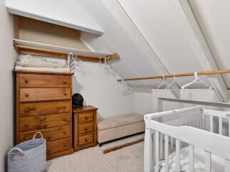 This charming nursery features a cozy, slanted-ceiling design, perfect for creating a warm and inviting space.