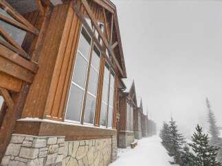 Experience the charm of this stunning property, featuring a beautiful wooden exterior and large windows that offer breathtaking views.