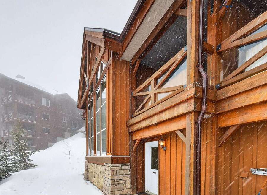 This stunning mountain home boasts exquisite wooden architecture and a cozy ambiance, perfect for a winter getaway.