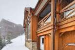 This stunning mountain home boasts exquisite wooden architecture and a cozy ambiance, perfect for a winter getaway.