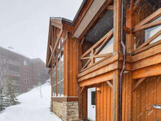 This stunning mountain home boasts exquisite wooden architecture and a cozy ambiance, perfect for a winter getaway.