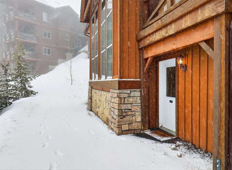 This stunning property boasts a beautiful exterior with wooden siding and stone accents, creating a warm and inviting atmosphere.