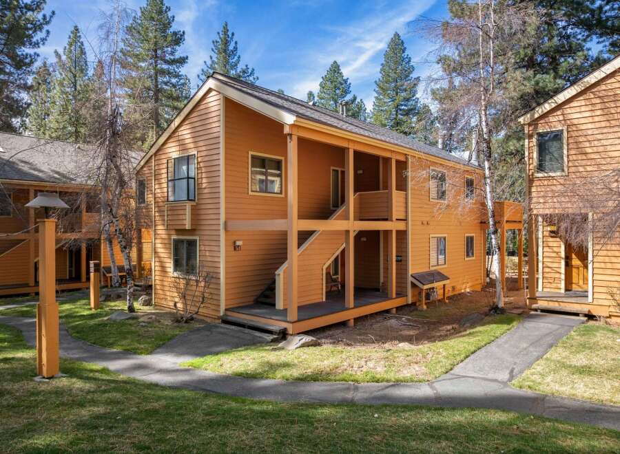 This charming two-story property offers a warm and inviting exterior with its wooden siding and inviting porch.