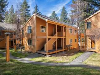 This charming two-story property offers a warm and inviting exterior with its wooden siding and inviting porch.
