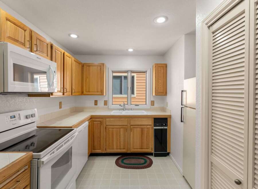 Step into this inviting kitchen, featuring classic wooden cabinetry and ample counter space, perfect for meal preparation.