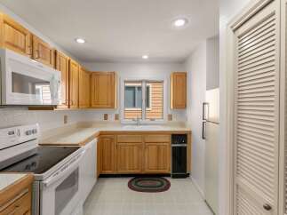 Step into this inviting kitchen, featuring classic wooden cabinetry and ample counter space, perfect for meal preparation.