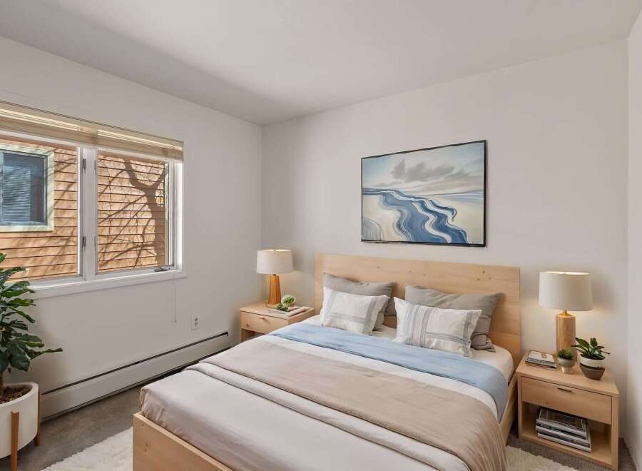This cozy bedroom offers a serene retreat with its natural wood accents and calming color palette.