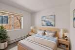 This cozy bedroom offers a serene retreat with its natural wood accents and calming color palette.
