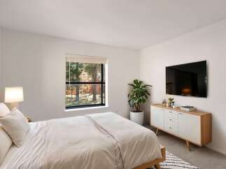 This modern bedroom offers a serene retreat with its minimalist design and natural light.