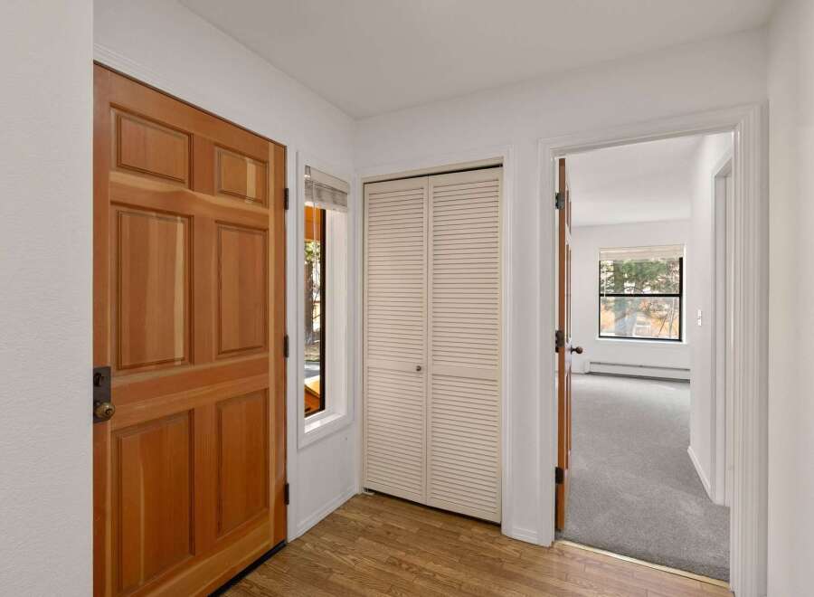 Step into this inviting entryway, showcasing a warm wooden door and a convenient closet.