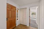 Step into this inviting entryway, showcasing a warm wooden door and a convenient closet.