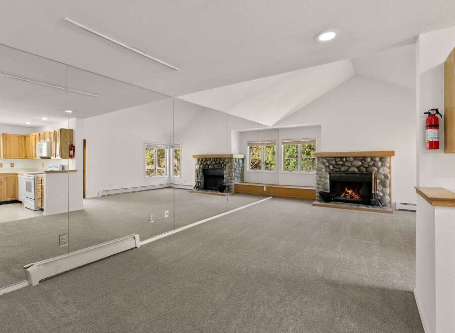 This stunning property boasts a spacious living area with a unique design, featuring a large mirror that enhances the sense of space and light.