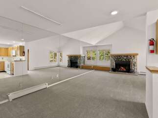 This stunning property boasts a spacious living area with a unique design, featuring a large mirror that enhances the sense of space and light.