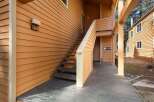 Discover the charm of this inviting property, featuring a welcoming exterior with a wooden deck and staircase.