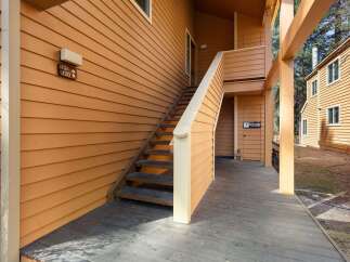 Discover the charm of this inviting property, featuring a welcoming exterior with a wooden deck and staircase.