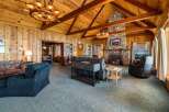 Step into luxury with this stunning property featuring a cozy living room with a fireplace and a rustic wooden ceiling.
