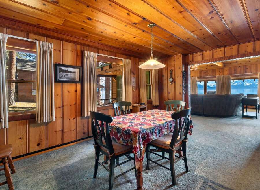 Step into a cozy dining room with stunning wood paneling and a charming floral tablecloth.