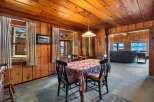 Step into a cozy dining room with stunning wood paneling and a charming floral tablecloth.