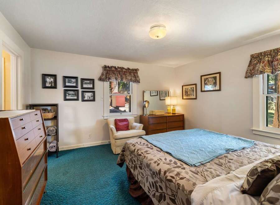 Step into this inviting bedroom, featuring a cozy ambiance and ample natural light.