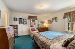 Step into this inviting bedroom, featuring a cozy ambiance and ample natural light.