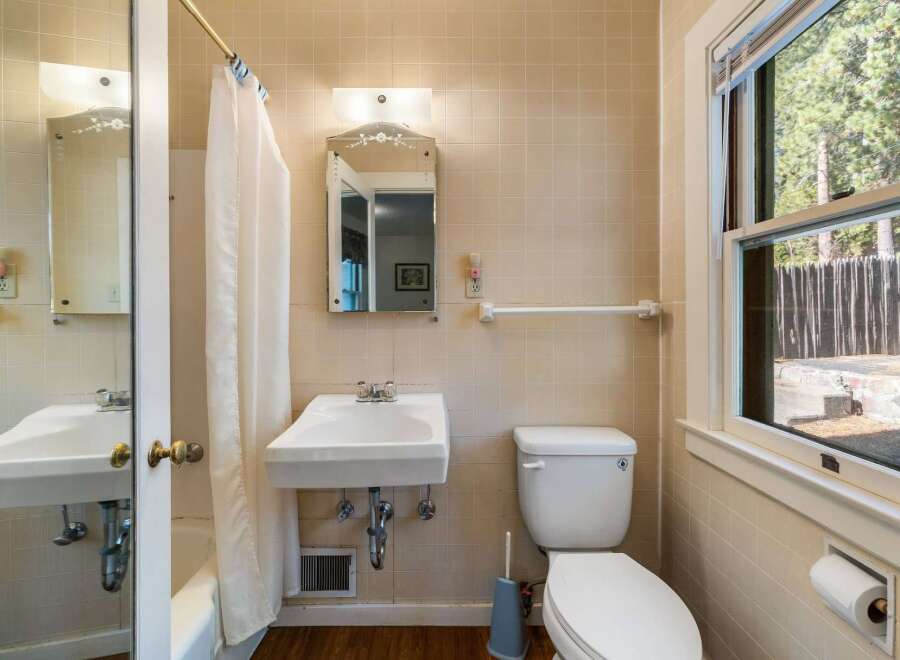Step into this charming bathroom, featuring classic tile work and a bright, airy feel.