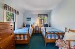This charming bedroom features two twin beds with cozy bedding, perfect for guests or family.