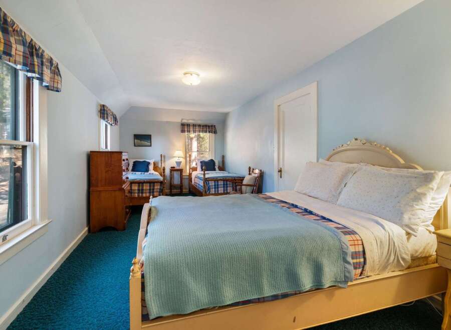 This charming bedroom features three beds, perfect for accommodating guests or family.