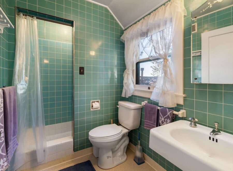 Step into this charming bathroom featuring classic green tile and a vintage aesthetic.