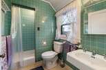 Step into this charming bathroom featuring classic green tile and a vintage aesthetic.