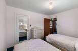 This charming bedroom features two twin beds with floral bedding, perfect for guests or family.