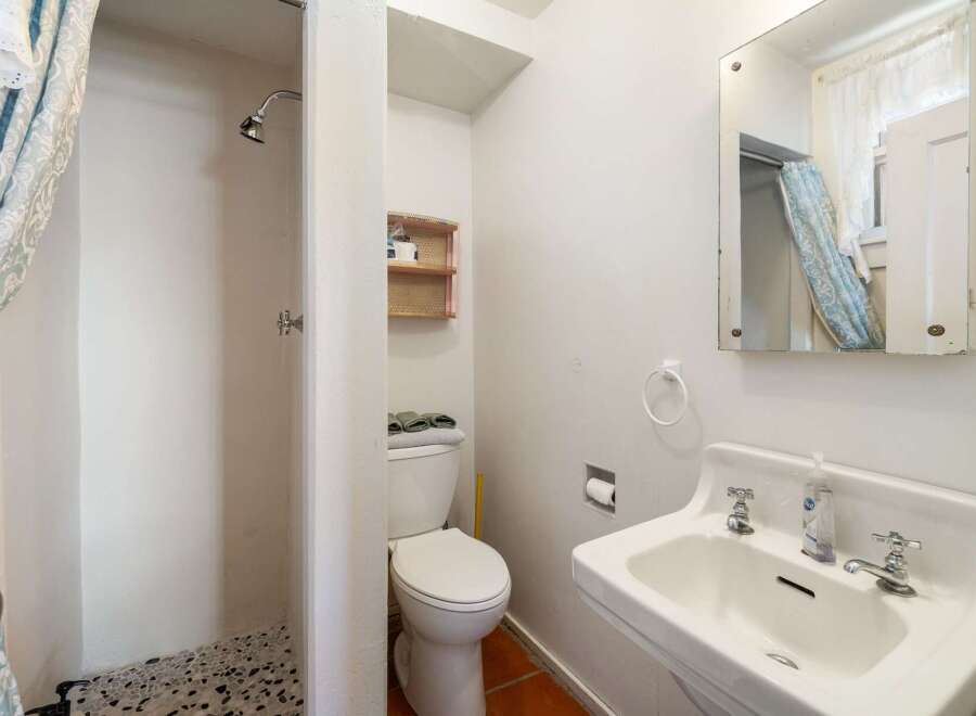 This charming bathroom features a unique shower design and a classic sink.