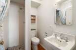 This charming bathroom features a unique shower design and a classic sink.