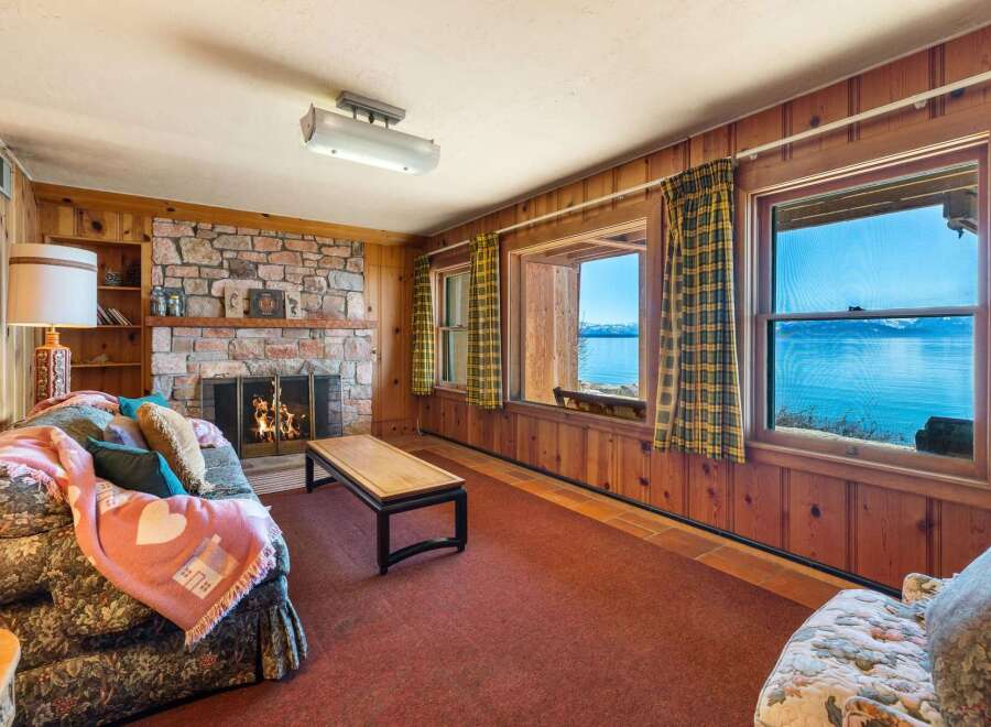Cozy up in this charming living room with a stunning lake view.