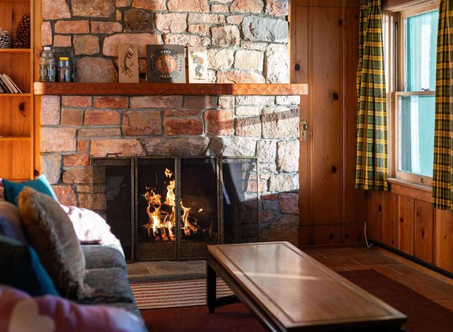 Cozy up in this charming living space, featuring a stunning stone fireplace that serves as the heart of the home.