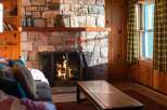 Cozy up in this charming living space, featuring a stunning stone fireplace that serves as the heart of the home.