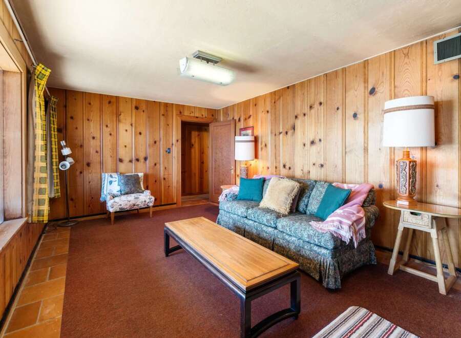 Step into this inviting living space, featuring warm wood paneling and a cozy atmosphere.