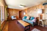 Step into this inviting living space, featuring warm wood paneling and a cozy atmosphere.