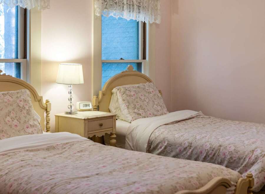 Charming bedroom featuring two twin beds with floral bedding, perfect for guests or a cozy retreat.