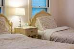 This charming bedroom features two twin beds with floral bedding, creating a cozy and inviting atmosphere.