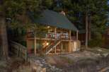 This charming cabin offers a serene retreat with its inviting exterior and picturesque setting.