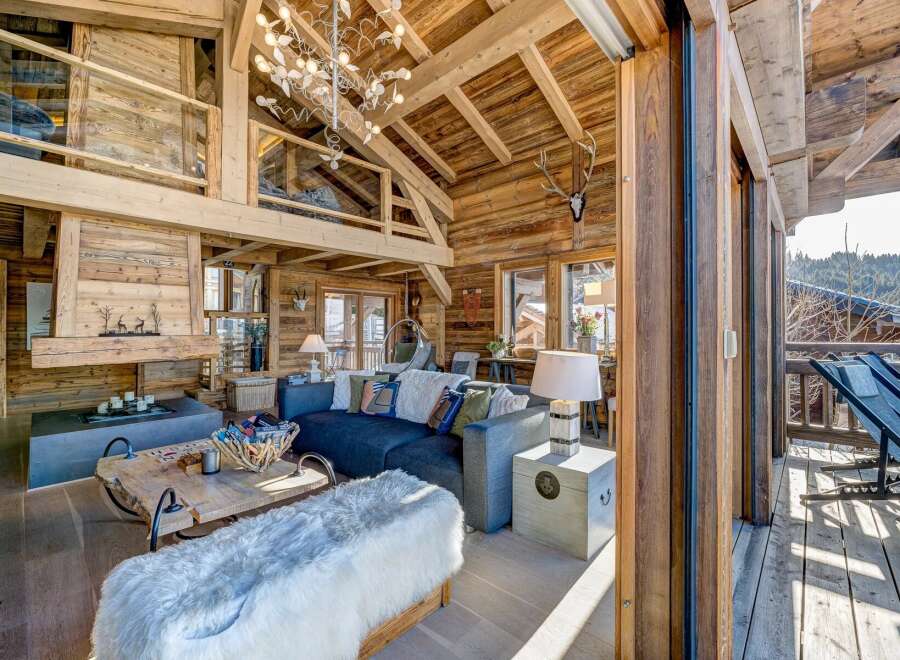 Experience rustic luxury in this stunning chalet, featuring exposed wooden beams and a cozy fireplace.