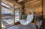 Experience ultimate relaxation in this stunning chalet, featuring a unique hanging chair and a cozy, inviting atmosphere.