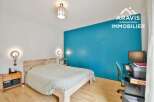 Discover this inviting bedroom featuring a comfortable bed and a stylish blue accent wall.