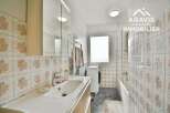 Discover this charming bathroom featuring a modern sink and a convenient washing machine.