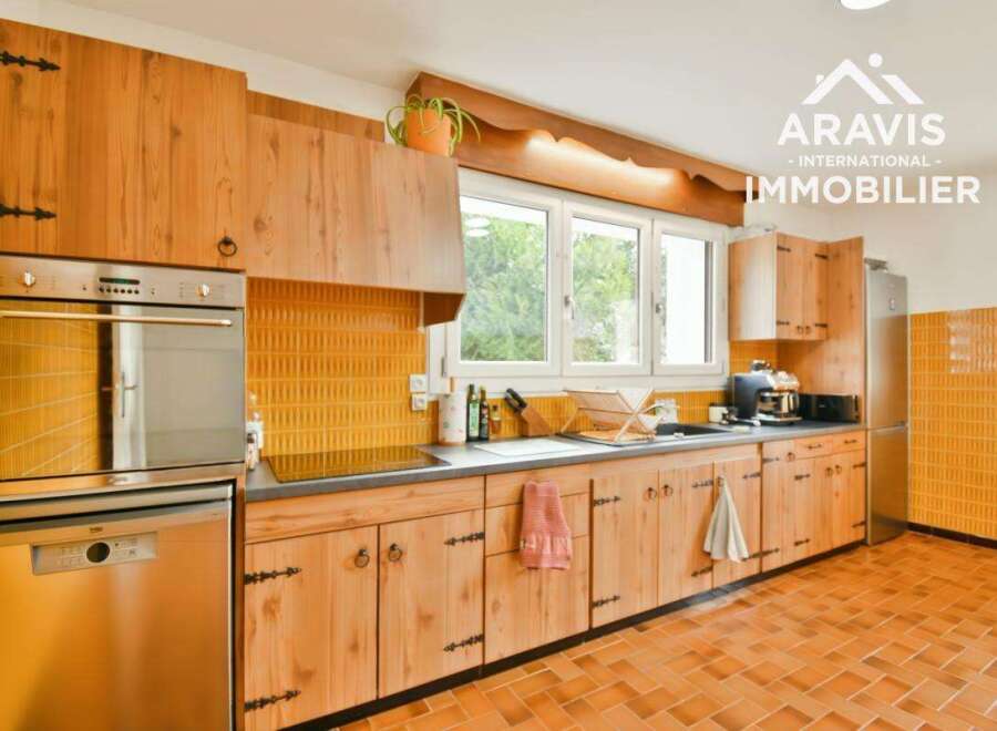 Step into this charming kitchen, featuring warm wooden cabinetry and a vibrant yellow tiled backsplash.
