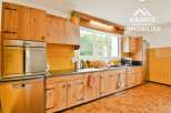 Step into this charming kitchen, featuring warm wooden cabinetry and a vibrant yellow tiled backsplash.