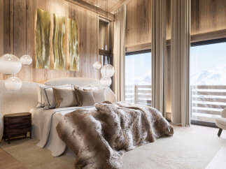 Experience luxury living in this stunning bedroom, featuring a cozy bed adorned with plush bedding and a faux fur throw.