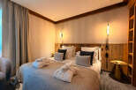 Experience ultimate comfort in this beautifully appointed bedroom, featuring a plush king-size bed adorned with soft linens and decorative pillows.