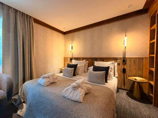 Experience ultimate comfort in this beautifully appointed bedroom, featuring a plush king-size bed adorned with soft linens and decorative pillows.